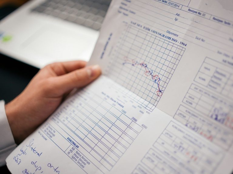 Hörtests Ein Hand hält ein Blatt mit den Ergebnissen eines Hörtests.